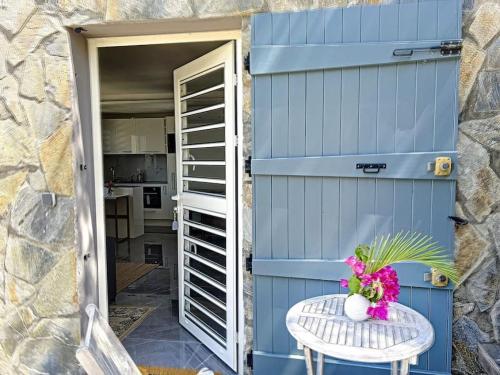 a blue garage door with a table and flowers on it at Studio Aloe in shared Villa Diamant, infinity pool, sea view in Grand Case