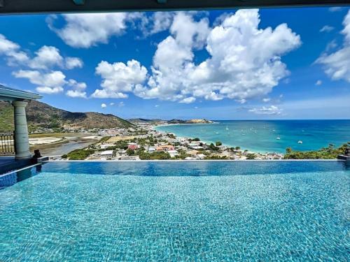 a swimming pool with a view of the ocean at Studio Aloe in shared Villa Diamant, infinity pool, sea view in Grand Case