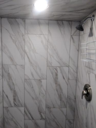 d'une douche avec un mur en marbre blanc. dans l'établissement Southsider Motel, à Coos Bay