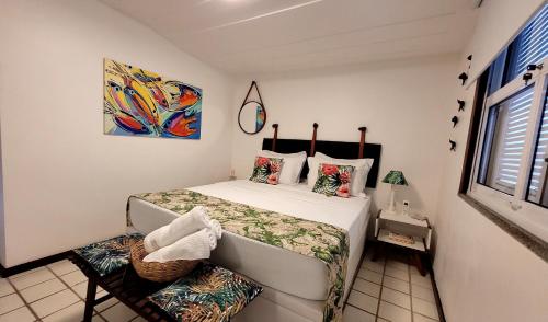 ein kleines Schlafzimmer mit einem Bett und einem Fenster in der Unterkunft Maison Bardot 1 - Casa em condomínio para 4 em Geribá, Búzios in Búzios