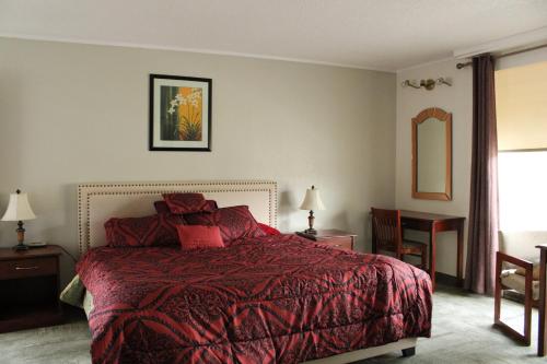 1 dormitorio con 1 cama con edredón rojo en American Travel Inn en Pullman