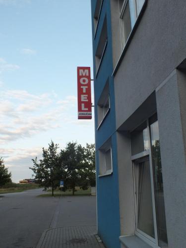 a blue building with a sign on the side of it at Motelis Jonučiai in Garliava