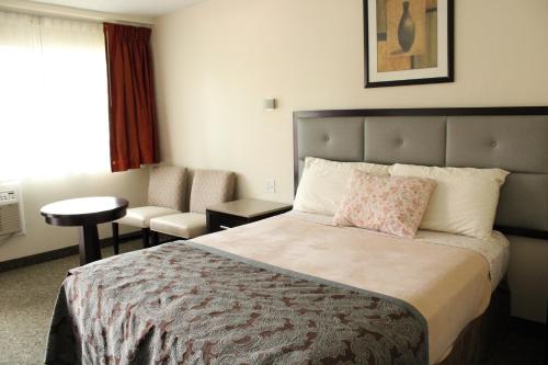 a hotel room with a bed and a chair at American Travel Inn in Pullman