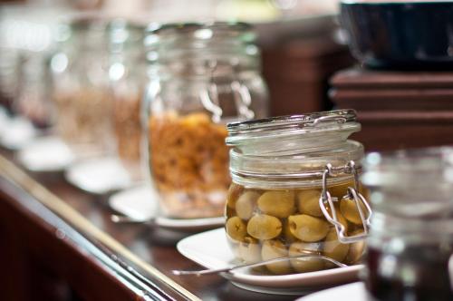a counter with jars of pickles and plates of food at MOXA Bucharest Boutique Hotel in Bucharest