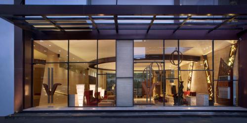 a large glass window of a building with furniture in it at de Vins Sky Hotel Seminyak in Seminyak