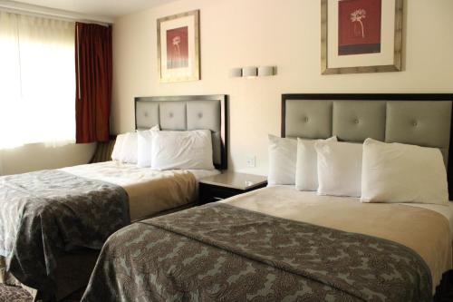 a hotel room with two beds and a window at American Travel Inn in Pullman