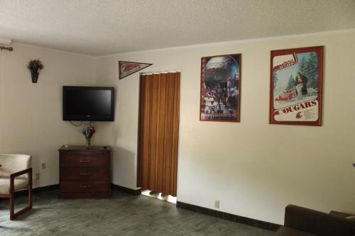 a living room with a flat screen tv on a wall at American Travel Inn in Pullman