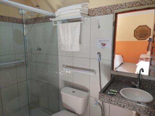 a bathroom with a shower and a toilet and a sink at Pousada Sonho de Mar in Luis Correia