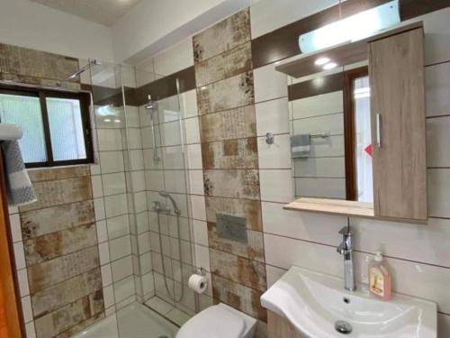 a bathroom with a shower and a toilet and a sink at Pleasing apartment in Mpenitses with terrace in Benitses