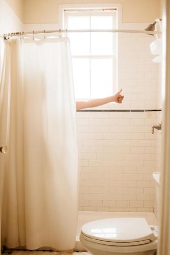 a bathroom with a white shower curtain and a toilet at La Villa de Adelina in Ensenada