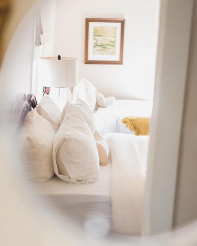 a room with white pillows and a white couch at La Villa de Adelina in Ensenada