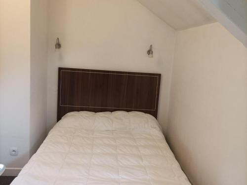 sypialnia z łóżkiem z drewnianym zagłówkiem w obiekcie Appartement T3 Mezzanine pour 6 Pers. avec Piscine et Sauna à Jausiers, Château des Magnans - FR-1-165B-9 w mieście Jausiers
