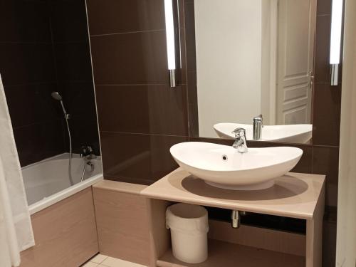 W łazience znajduje się biała umywalka i wanna. w obiekcie Appartement T3 Mezzanine pour 6 Pers. avec Piscine et Sauna à Jausiers, Château des Magnans - FR-1-165B-9 w mieście Jausiers