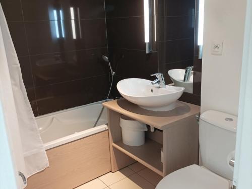 a bathroom with a sink and a toilet and a tub at Appartement Jausiers, 2 pièces, 4 personnes - FR-1-165B-42 in Jausiers