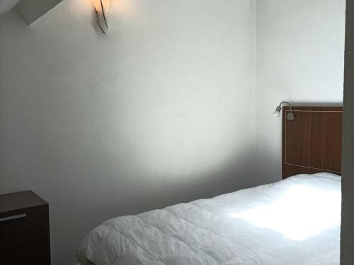 een slaapkamer met een bed en een lampje aan de muur bij Appartement Jausiers, 2 pièces, 4 personnes - FR-1-165B-42 in Jausiers