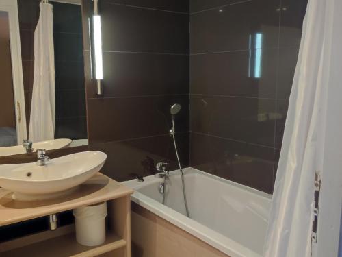 a bathroom with a white sink and a bath tub at Appartement Jausiers, 1 pièce, 6 personnes - FR-1-165B-22 in Jausiers
