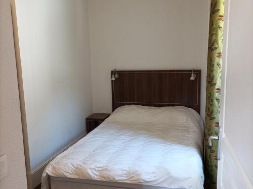 Dormitorio pequeño con cama con cabecero de madera en Appartement Jausiers, 2 pièces, 4 personnes - FR-1-165B-36 en Jausiers