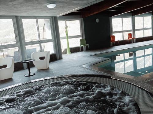 Cette chambre dispose d'une piscine avec des chaises et une table. dans l'établissement Studio cosy avec piscine, WiFi et parking - FR-1-165B-41, à Jausiers