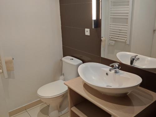 une salle de bain avec des toilettes blanches et un lavabo dans l'établissement Studio à Jausiers avec terrasse, piscine chauffée et parking, proche du Mercantour - FR-1-165B-43, à Jausiers