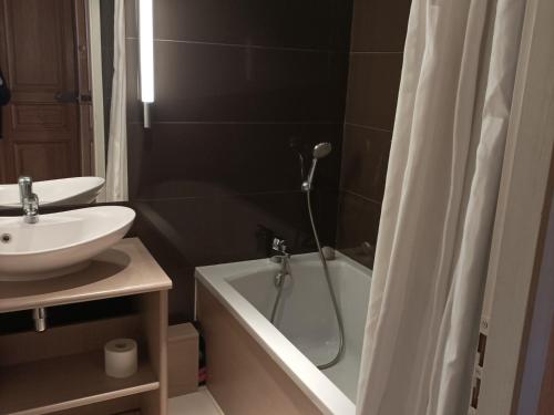 a bathroom with a sink and a tub and a shower at Appartement Jausiers, 2 pièces, 4 personnes - FR-1-165B-50 in Jausiers