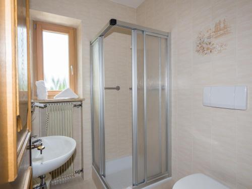 y baño con ducha, aseo y lavamanos. en Guesthouse Pension Grafenstein, en Merano