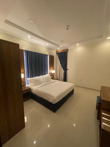 a hotel room with a bed and a window at Reef Al Qassim Hotel Apartments in Buraydah