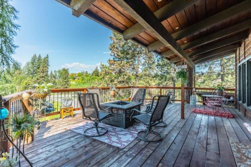 a deck with chairs and a table on it at Hilltop Hideaway in Bigfork