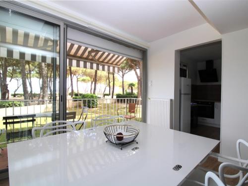 une salle à manger avec une table et des chaises blanches dans l'établissement Argelès-sur-Mer - T2 - Pieds dans l'eau - Tout confort - FR-1-309-343, à Argelès-sur-Mer