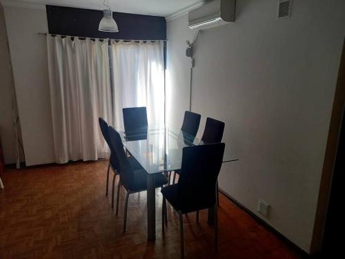 een eetkamer met een glazen tafel en stoelen bij Hermoso dpto centrico externo c/ balcones in Cordoba