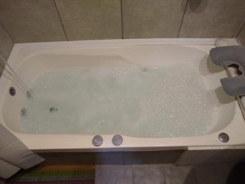 a bath tub filled with water in a bathroom at cabaña la casa del arbol in Tandil