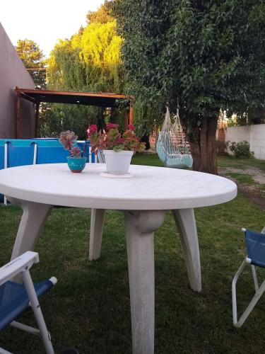 a white table with two vases of flowers on it at cabaña la casa del arbol in Tandil