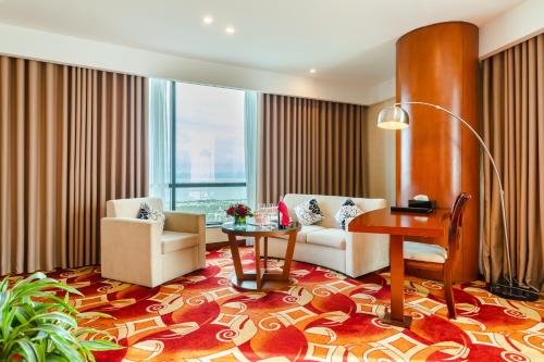 Cette chambre comprend un bureau, des chaises et une table. dans l'établissement Muong Thanh Luxury Quang Ninh Hotel, à Hạ Long