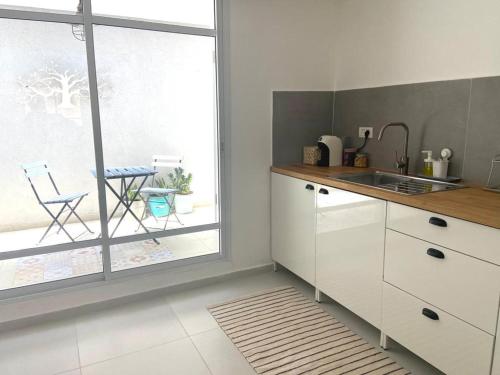 a white kitchen with a sink and a window at אירוח השקד - 10דק' משדה התעופה in Giv‘at Koaẖ