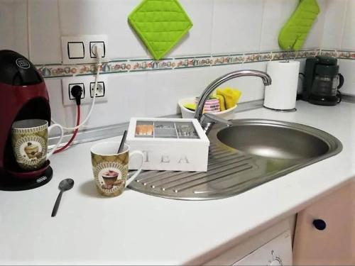 eine Küchentheke mit Spüle, Toaster und Tassen in der Unterkunft Duplex in Urb Naturista near Beach & Pool in Playas de Vera