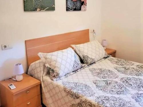 Un dormitorio con una cama con cabecero de madera y almohadas. en Belvilla by OYO Valle del Este las Yucas, en El Esparragal