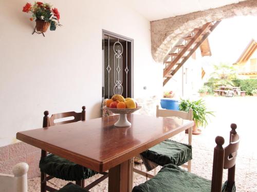 a dining room table with a bowl of fruit on it at Family Retreat near Garda in Ronzo Chienis