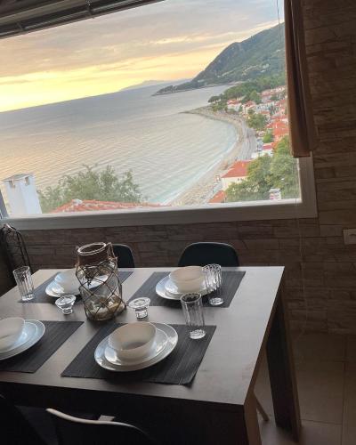 a dining table with a view of the beach at The Odyssey Holiday Home - Agios Ioannis, Pelion in Agios Ioannis Pelio
