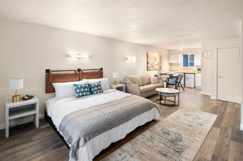 Hotel McCoy Pullman في بولمان: غرفة نوم بسرير كبير وغرفة معيشة