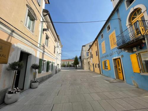 an empty alley with blue and yellow buildings at RITUAL in Ajdovščina