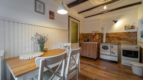Mala kuća في Vele Drage: مطبخ مع طاولة خشبية واجهزة بيضاء