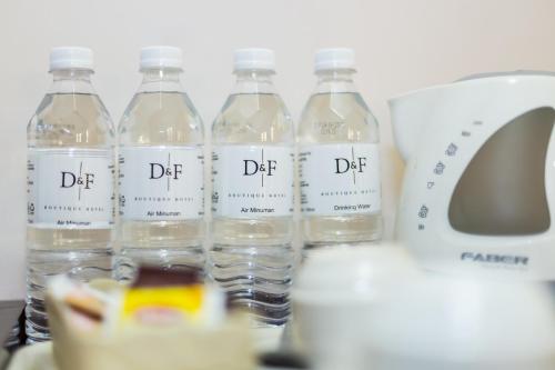 D&F BOUTIQUE HOTEL ERA SQUARE SEREMBAN في سِريمبان: مجموعة من زجاجات المياه جالسة على منضدة