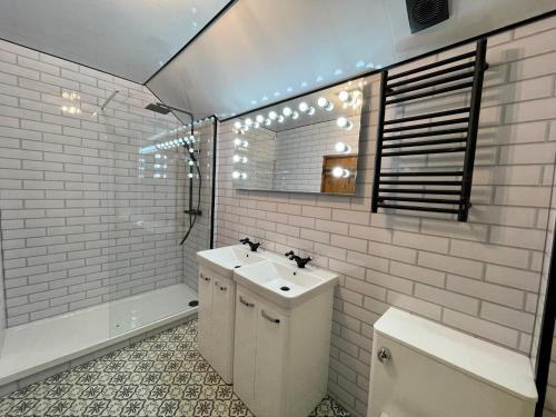 a bathroom with a sink and a toilet and a mirror at Cosy 2 bedroom apartment, terrace with Hot Tub 8am - 10pm plus private daily use of indoor pool and sauna 1 hour in Stanton in Peak
