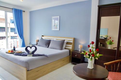 a bedroom with a bed with a swan decoration on it at GOLDEN GUESTHOUSE by The Beach Cha Am in Cha Am