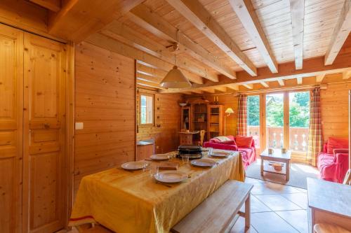 ein Esszimmer mit einem Tisch in einem Holzhaus in der Unterkunft Quiet apartment near the slopes in La Clusaz