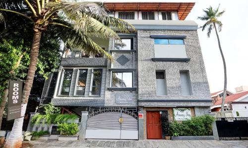 a house with a palm tree in front of it at Itsy By Treebo - Anurag Inn in Mysore