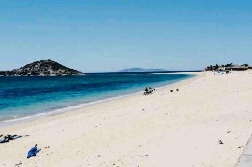a beach with people on the sand and water at Casa Totalmente Equipada en Playa Algodones in San Carlos