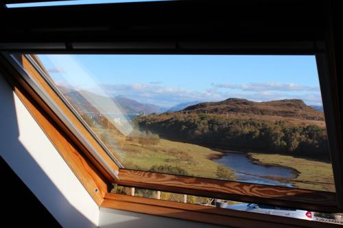 a window with a view of a river and mountains at Misty Isle Apartments Ltd - Maol View in Kyleakin