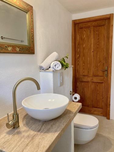 a bathroom with a sink and a toilet and a mirror at Apartments Mimoza Komiza in Komiža