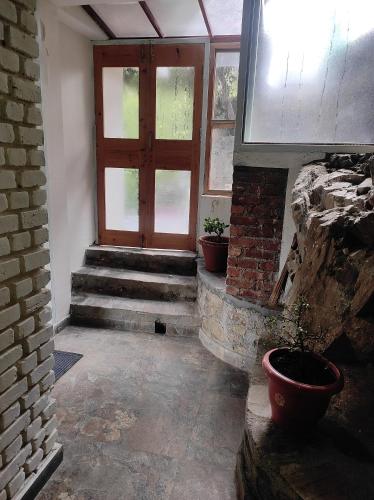 aoyer with a wooden door and a brick wall at Kainchi Boutique Homestay in Rāmgarh