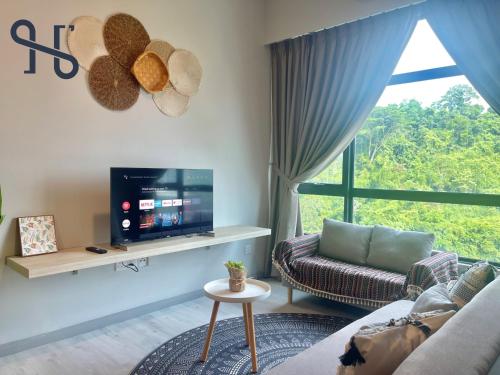 a living room with a couch and a tv at Homesuite' Home at Jesselton Quay in Kota Kinabalu